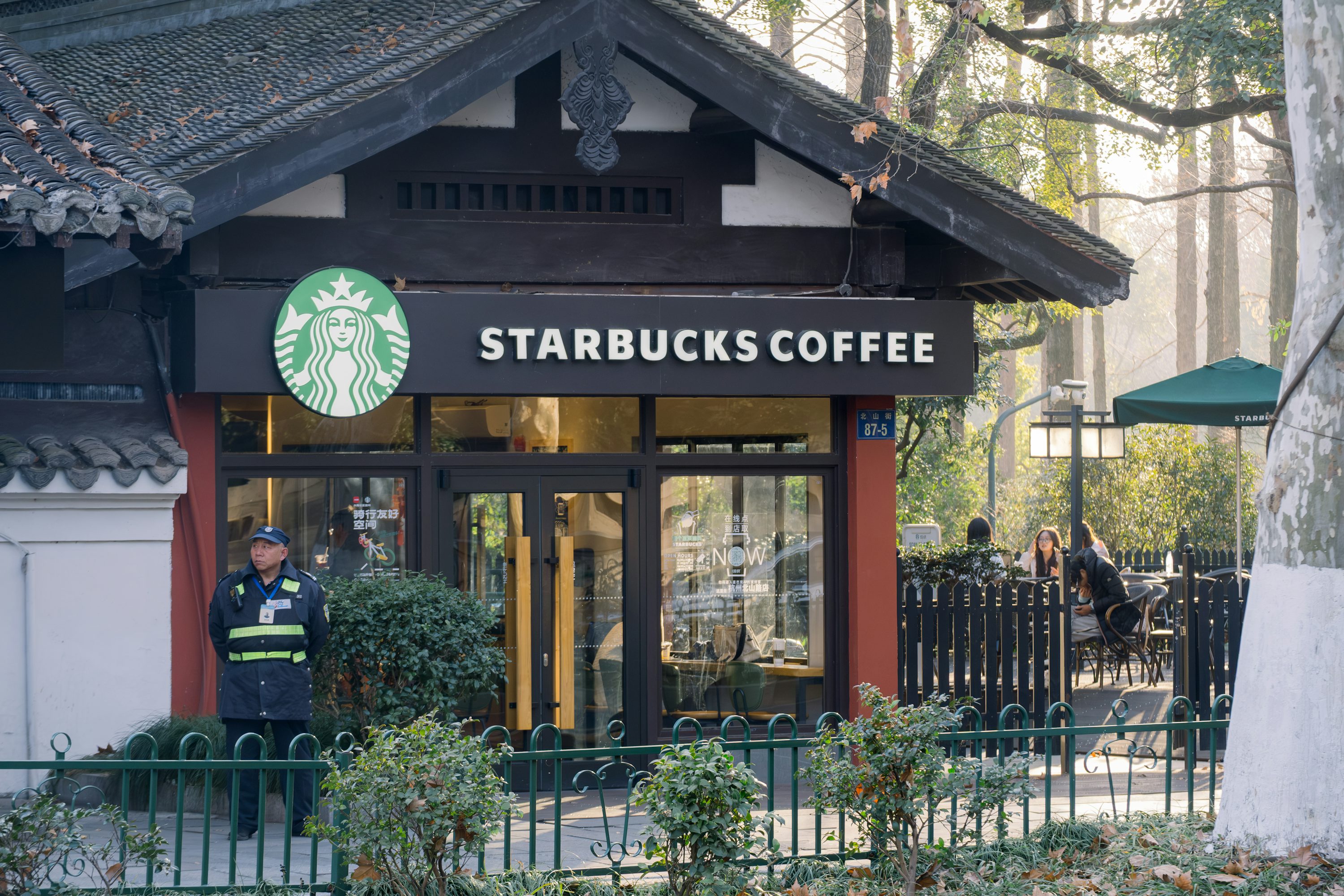 Prodejna Starbucks s logem zelené sirény za slunečného dne